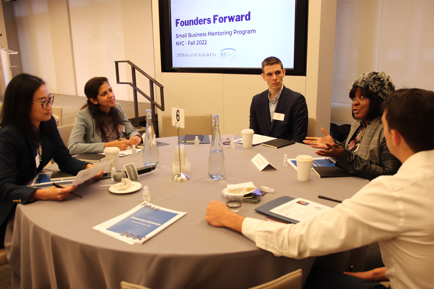 A group of Founders Forward mentors meets with a participating entrepreneur.